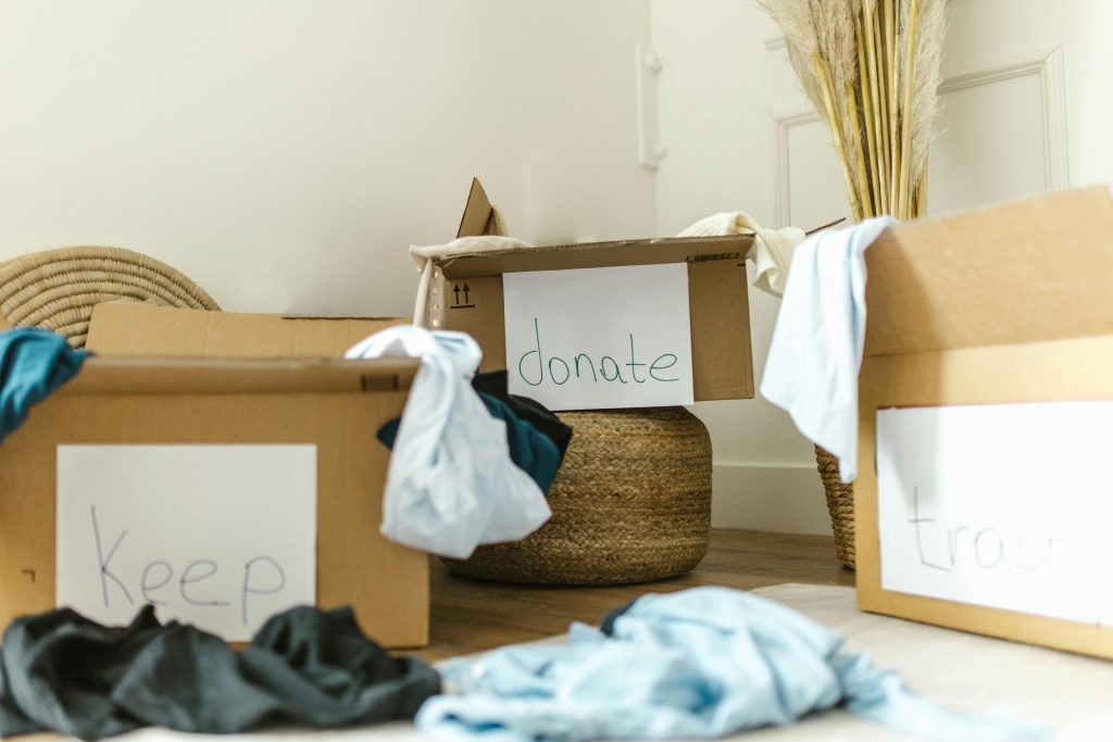 Cardboard boxes labeled keep, donate, and trash for effective home organization. Des boîtes en carton étiquetées "garder", "donner" et "jeter" pour une organisation efficace de la maison.