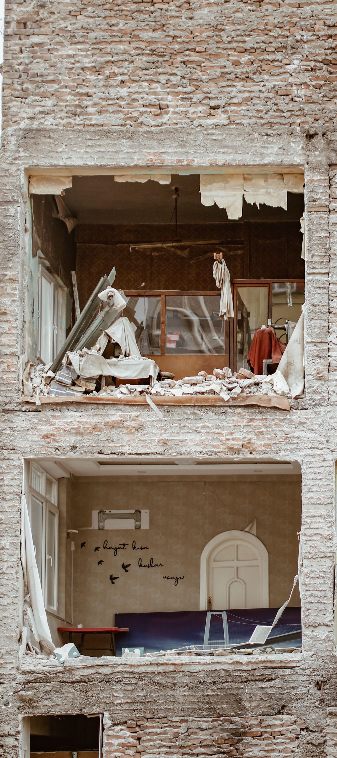 A detailed view of a damaged and abandoned building showcasing urban decay. Une vue détaillée d'un bâtiment endommagé et abandonné mettant en évidence la décadence urbaine.
