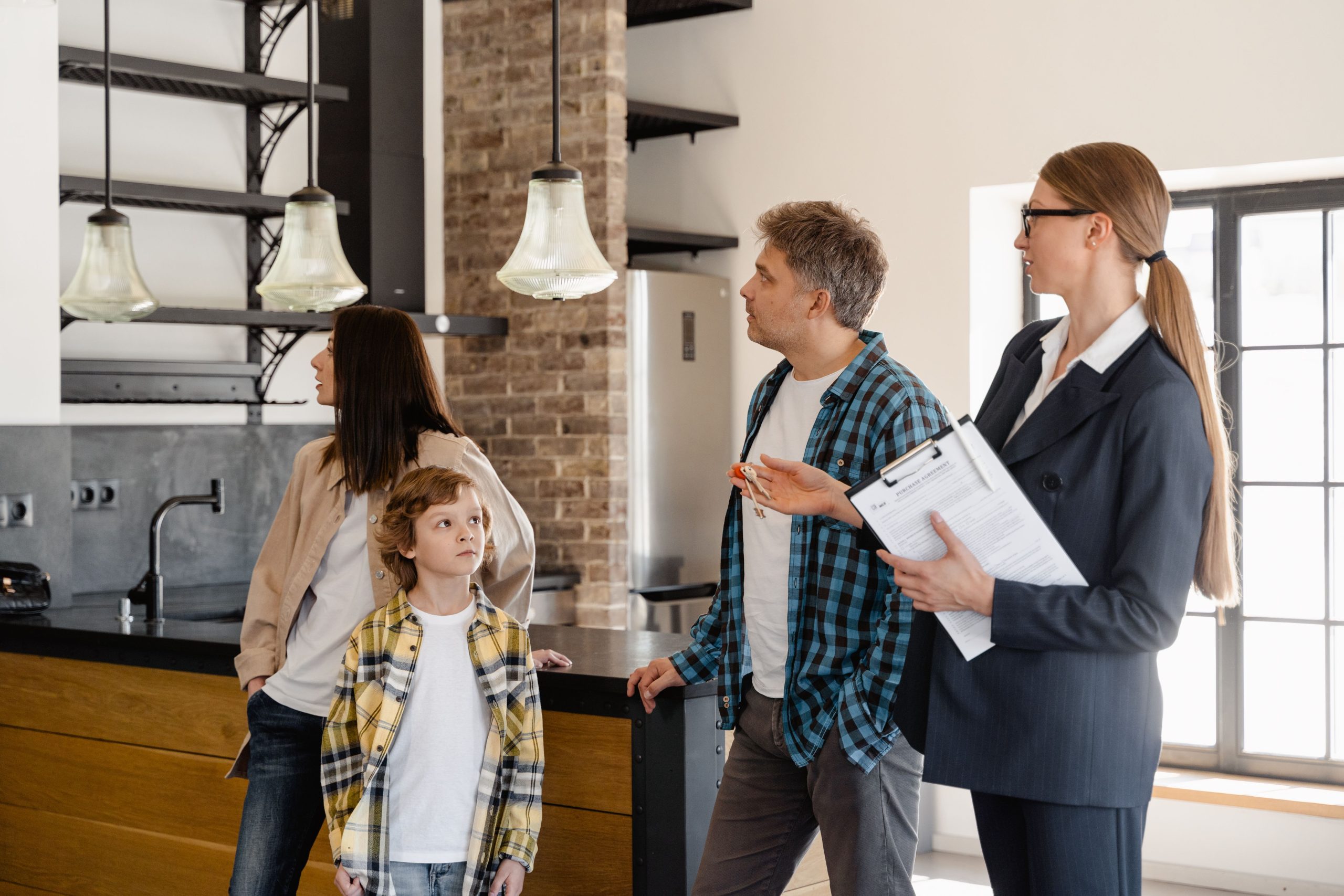 A family converses with a real estate agent about a modern home interior. Une famille discute avec un agent immobilier à propos de l'intérieur d'une maison moderne.