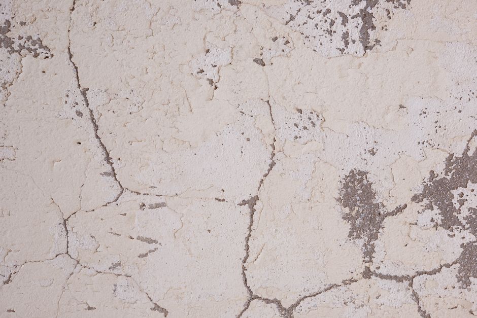 Gros plan sur une fissure dans un enduit de mur