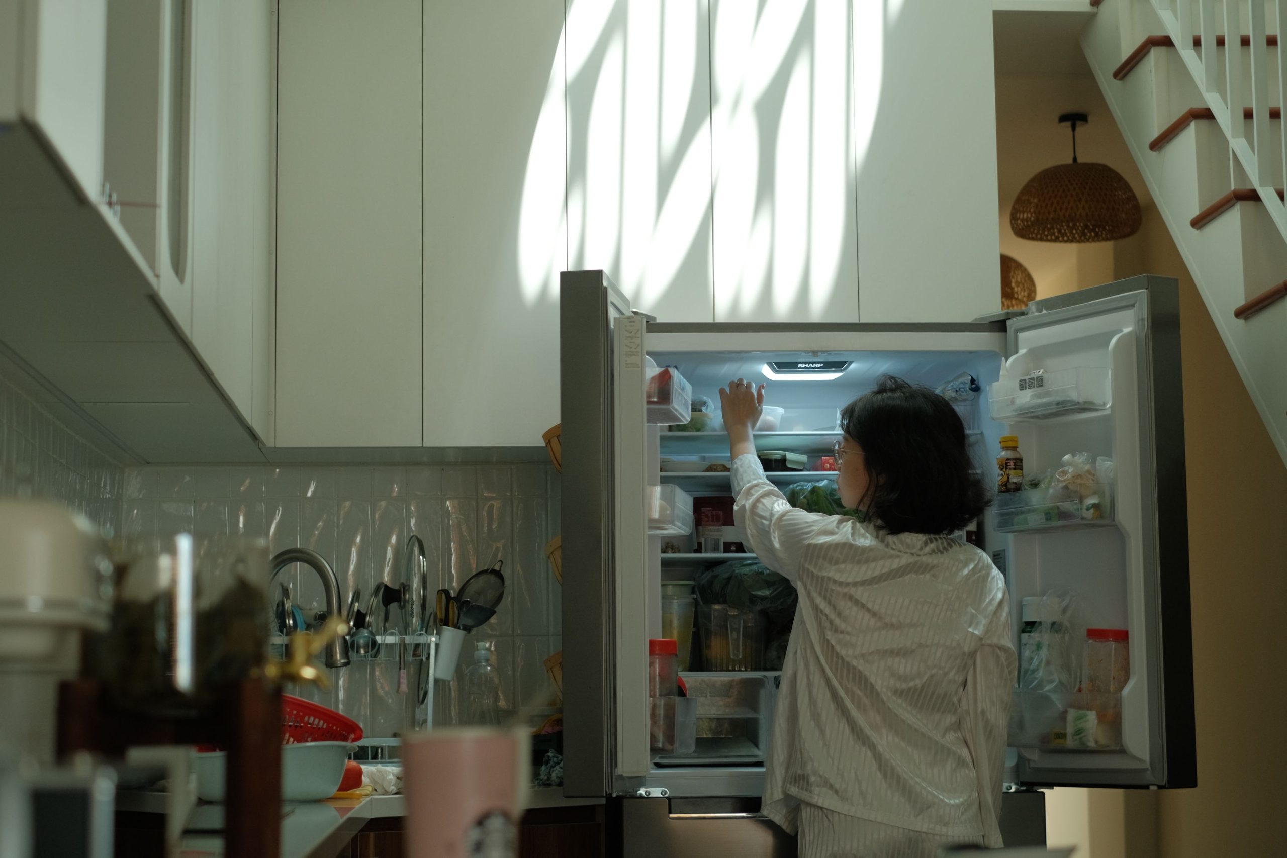 Vérification du réfrigérateur en soirée dans une cuisine chaleureuse