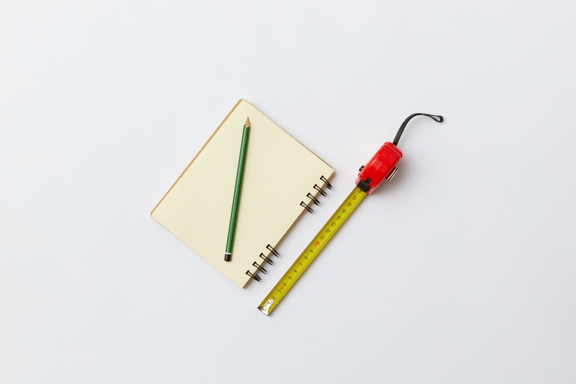Carnet, crayon et mètre ruban rouge