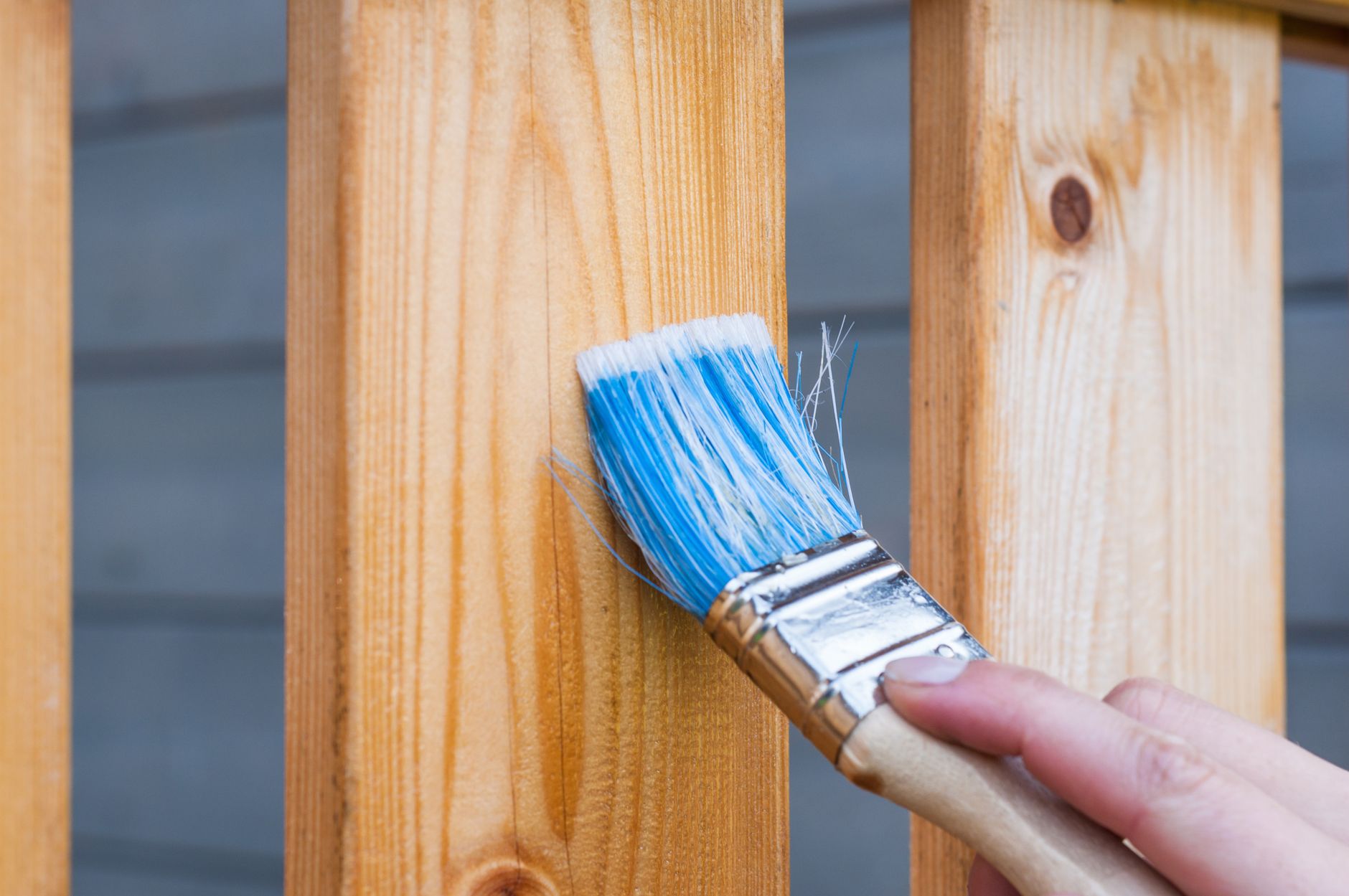 Pinceau bleu sur une planche de bois à finir